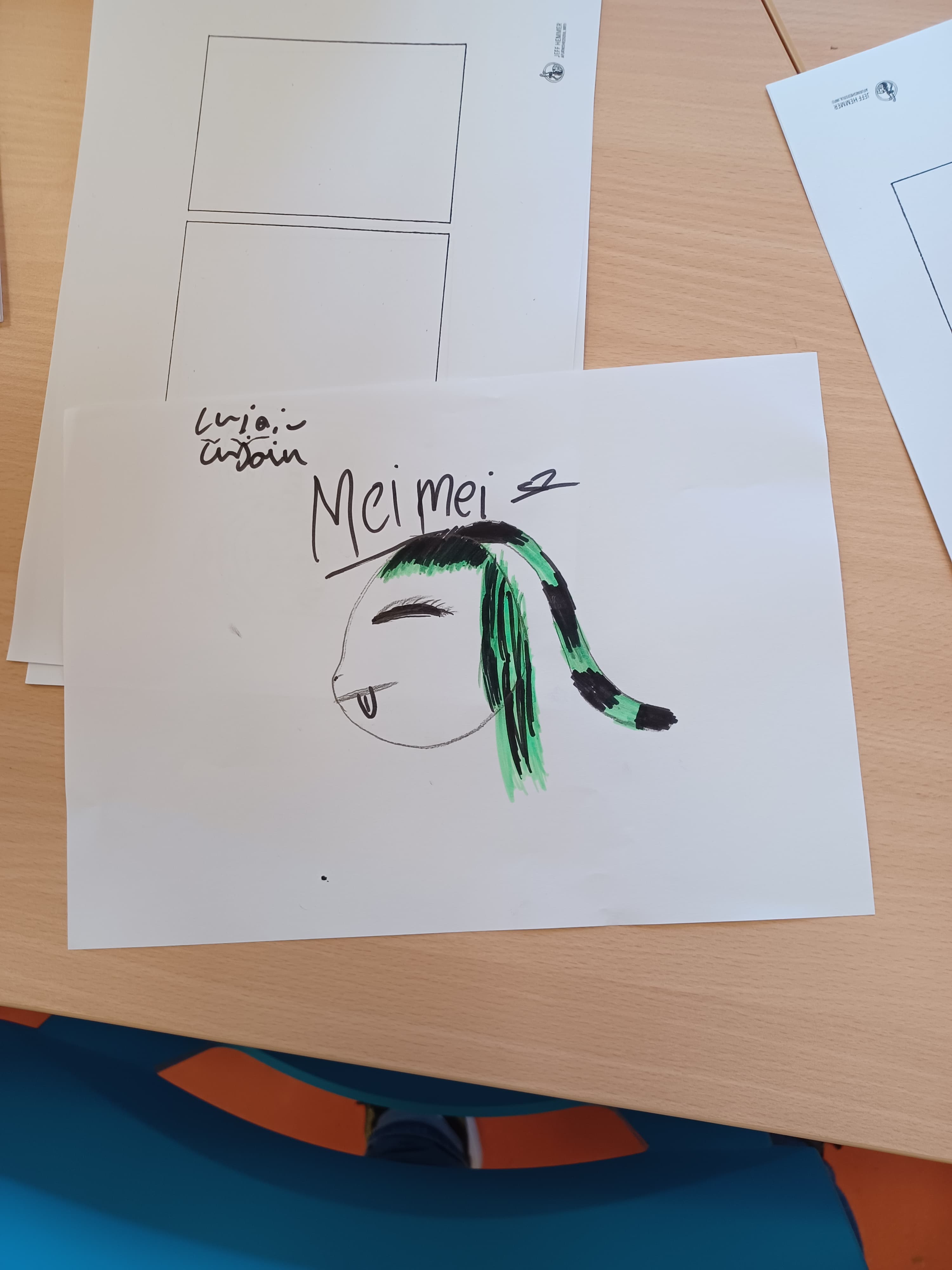 Zeichnungen liegen auf einem Holztisch.